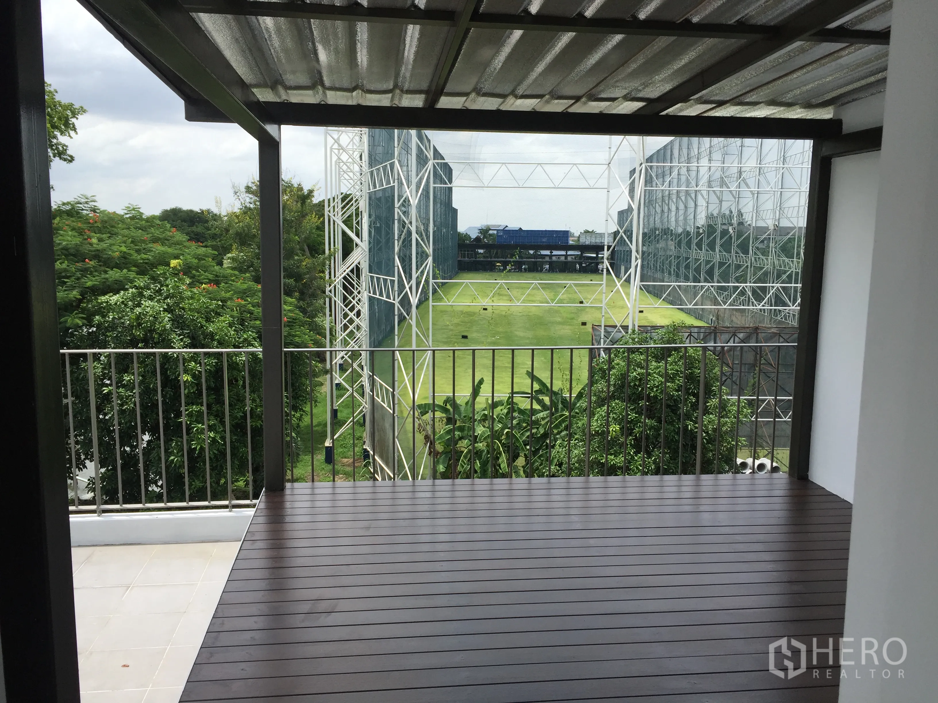 Townhouse for rent in Bang Kapi, Bangkok - Covered terrace with railing overlooking greenery and the nearby golf driving range.