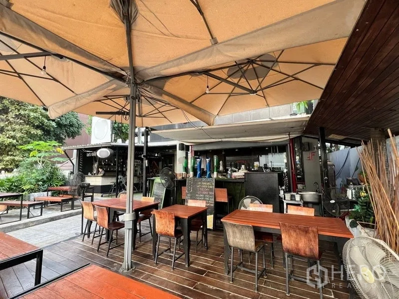 Retail Space for rent in Watthana, Bangkok - Shaded patio seating under umbrellas with fans and a bar area in the background.
