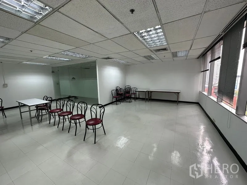 Office Space for rent in Chatuchak, Bangkok - Spacious open-plan workspace with tiled floors, glass-partitioned corner and chairs.