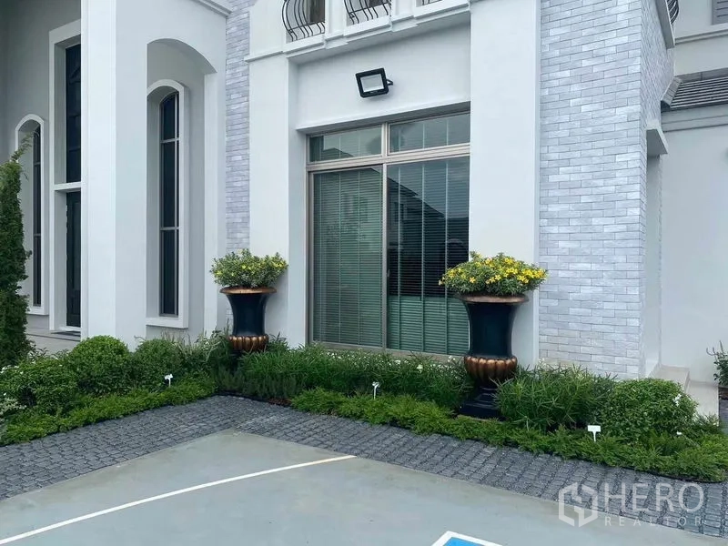 独立式住宅 出售在Lat Krabang, Bangkok - 立面细节，拱形窗与花盆点缀。