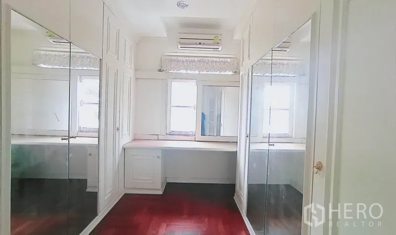 独立式住宅 出售在Bang Kapi, Bangkok - 步入式衣帽间，镜面衣柜、白色柜体与梳妆台。