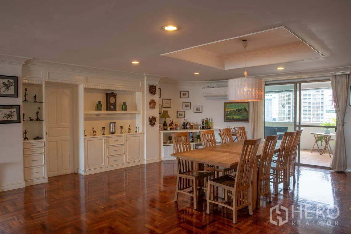 อพาร์ทเมนท์ for rent in Khlong Toei, Bangkok - ห้องทานอาหารพร้อมโต๊ะไม้ยาว ตู้บิวท์อิน และทางออกสู่ระเบียง.