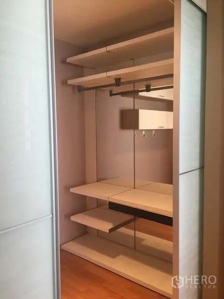 Condominium for rent - Additional walk-in closet with sliding doors, shelves, and mirrored back panel.