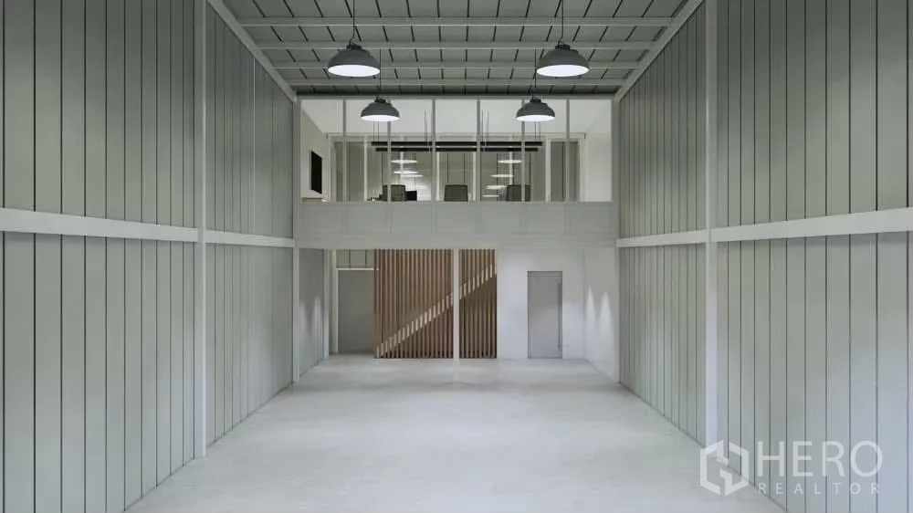 货栈 出租在Prawet, Bangkok - 仓库内部朝向夹层办公室，工业吊灯与金属墙板。