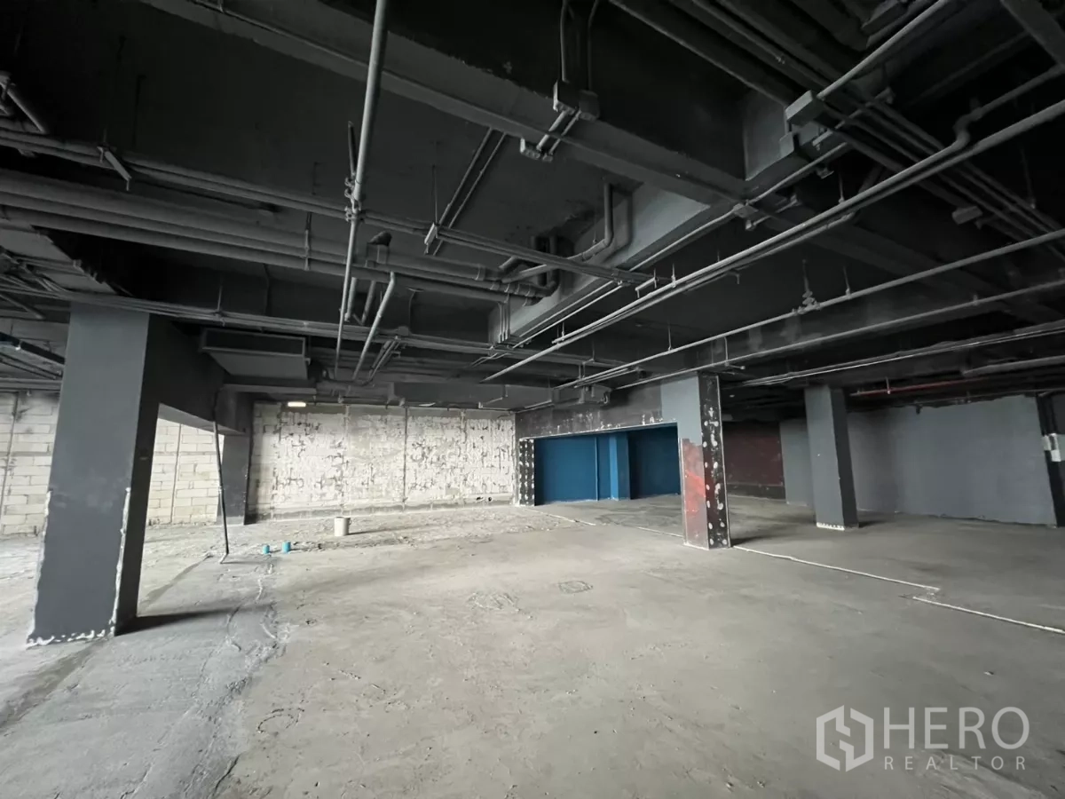 Retail Space for rent in Watthana, Bangkok - Raw retail floor with concrete finish and feature columns.