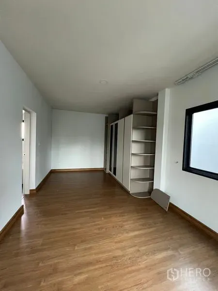 Detached House for rent or sale in Bang Phli, Samut Prakan - Empty room with built-in open shelving and wood floor, ideal as a walk-in closet or study.