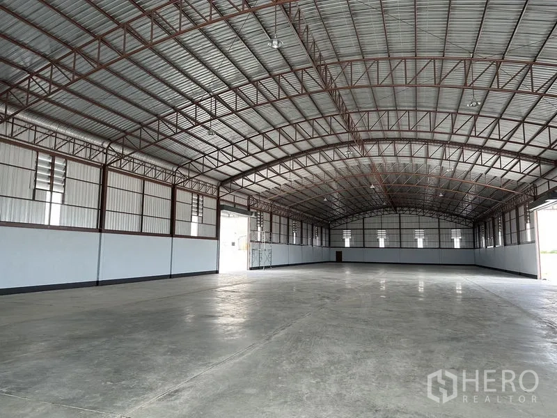 Factory for rent or sale in Sai Noi, Nonthaburi - Open warehouse space with steel framing, bright side panels and unobstructed floor area.
