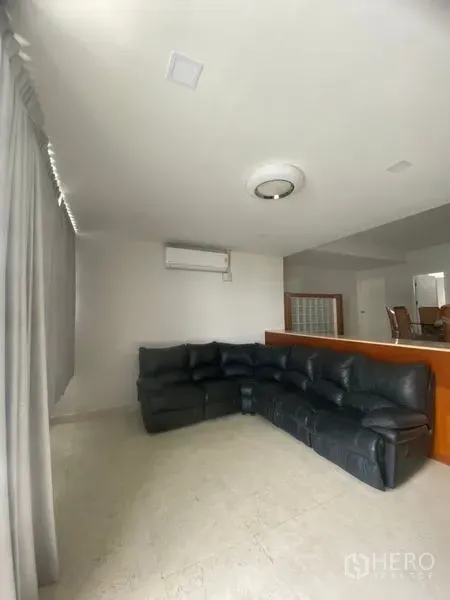 คอนโด ให้เช่าในSathon, Bangkok - ห้องนั่งเล่นสว่าง โซฟาหนังสีดำตัวใหญ่ พื้นกระเบื้อง แอร์ และผ้าม่านเต็มบาน