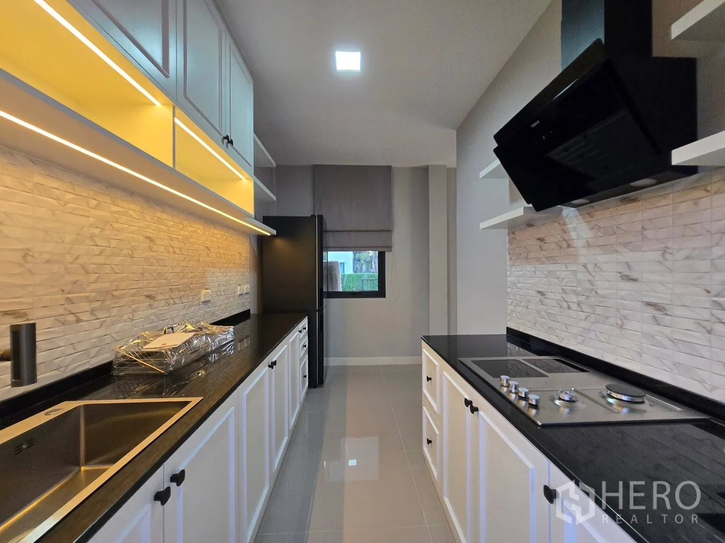 บ้าน for rent or sale in Bang Phli, Samut Prakan - ครัวรูปแบบทางเดิน ตู้เชคเกอร์สีขาว ท็อปสีดำ เตาไฟฟ้าและฮูดดูดควัน