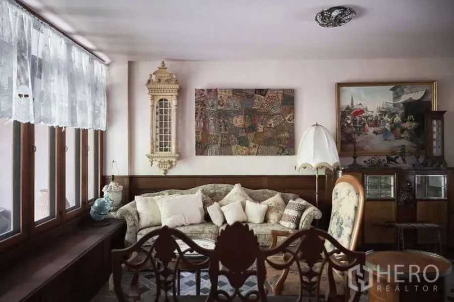 联排别墅 出租在Khlong Toei, Bangkok - 舒适客厅，蕾丝窗帘、经典沙发与装饰画