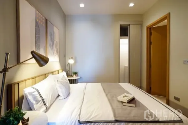 公寓 出租在Watthana, Bangkok - 次卧配双人床，暖色灯光，临近卫生间。