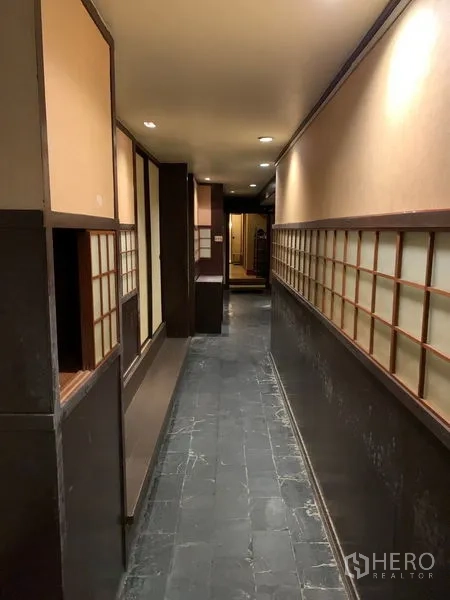 Retail Space for rent in Bang Rak, Bangkok - Long corridor with stone flooring and shoji-style wall panels under soft lighting.