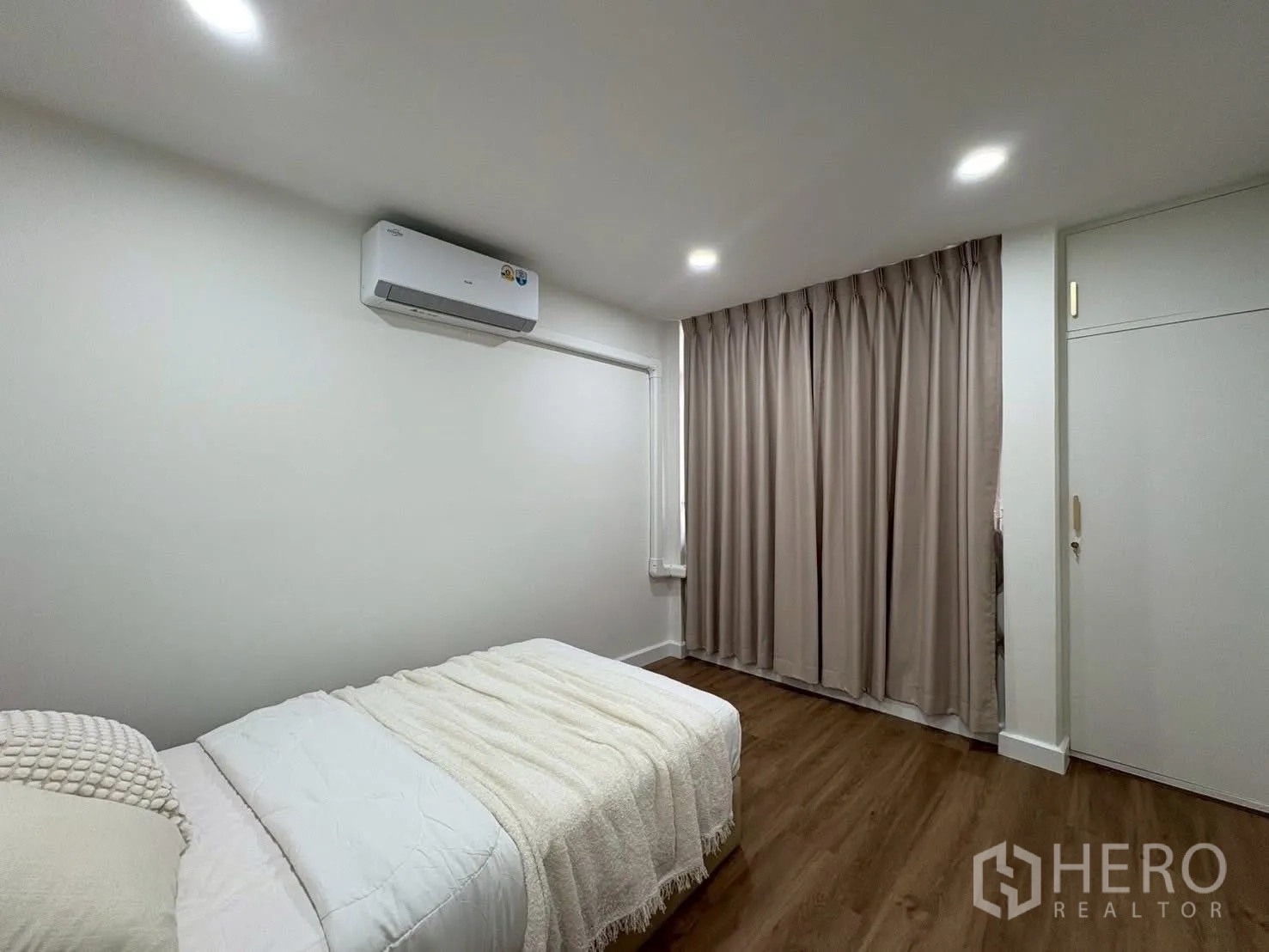 Detached House for rent in Huai Khwang, Bangkok - Guest bedroom with blackout curtains and wood flooring