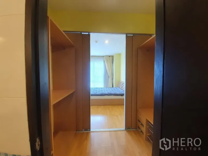 Condominium for rent in Khlong Toei, Bangkok - Built-in walk-in closet with shelving on both sides leading into the bedroom.