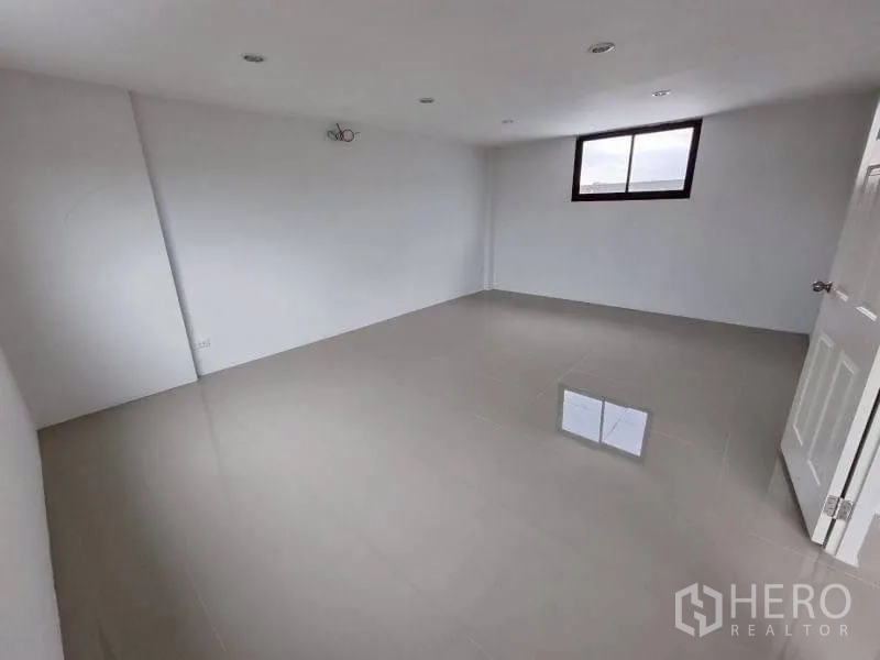 Warehouse for rent in Lam Luk Ka, Pathum Thani - Unfurnished room with glossy floor tiles and a window for light.
