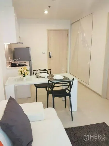 Condominium for rent in Khlong Toei, Bangkok - Open-plan living and dining area with two-seat table beside the kitchen.