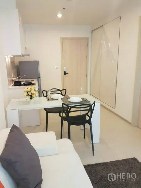 Condominium for rent in Khlong Toei, Bangkok - Open-plan living and dining area with two-seat table beside the kitchen.