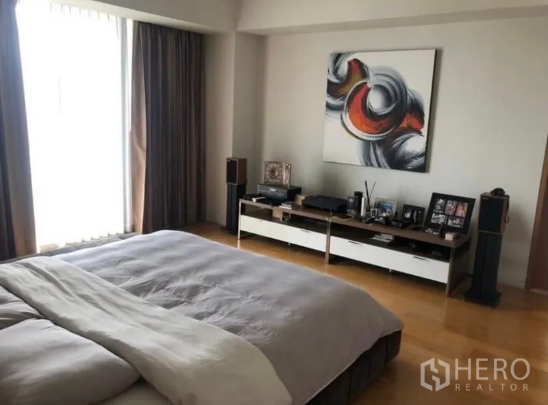 Condominium for rent in Sathon, Bangkok - Primary bedroom with artwork, console and large windows