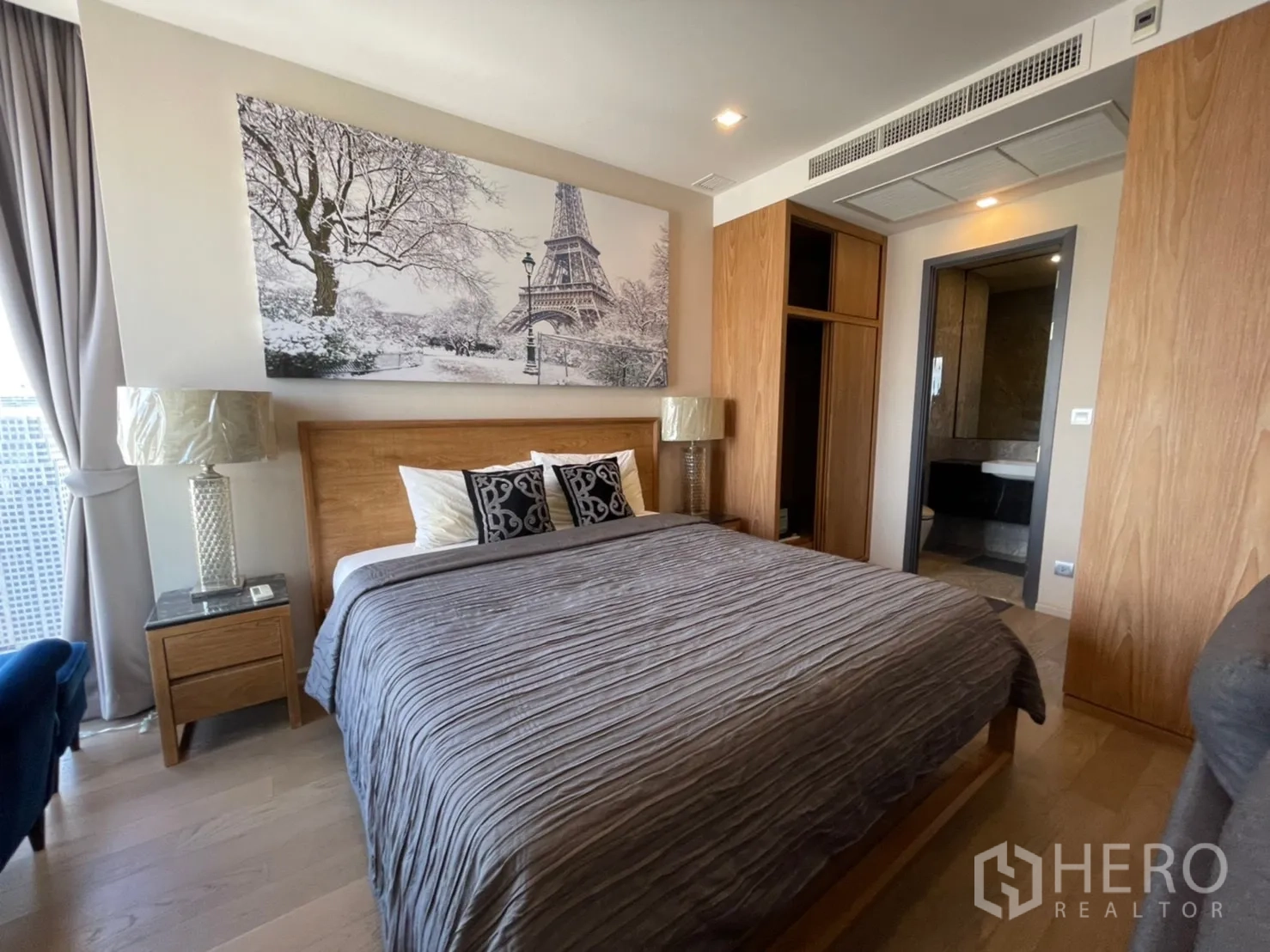 คอนโด for rent in Watthana, Bangkok - ห้องนอนอบอุ่นด้วยเตียงไม้ โต๊ะข้างเตียง และประตูเชื่อมห้องน้ำ