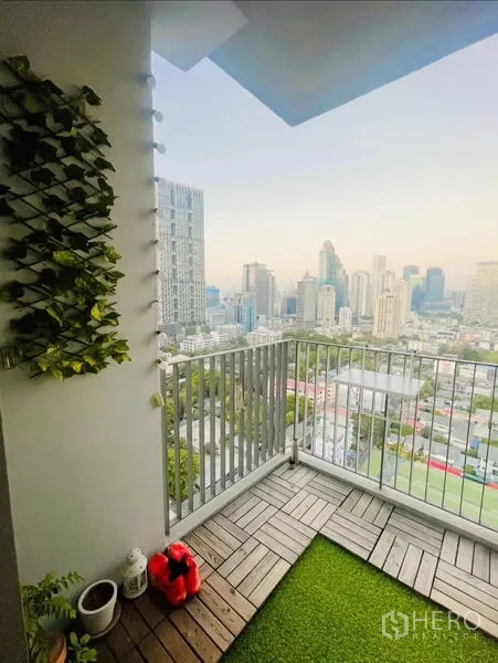 Condominium for rent or sale in Sathon, Bangkok - Small balcony with wood decking, artificial grass and open city view.
