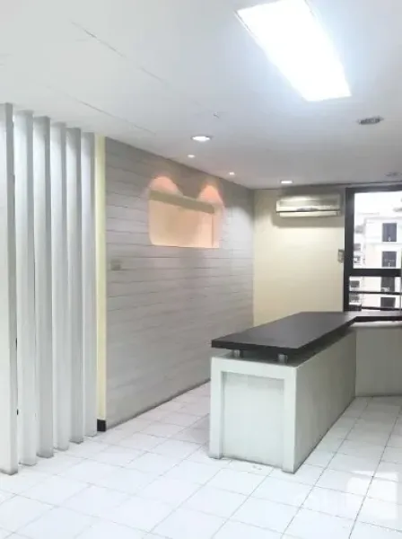 Office Space for rent in Bang Rak, Bangkok - Bright office corner with built-in counter, white tile floor, vertical partition and window with AC unit.