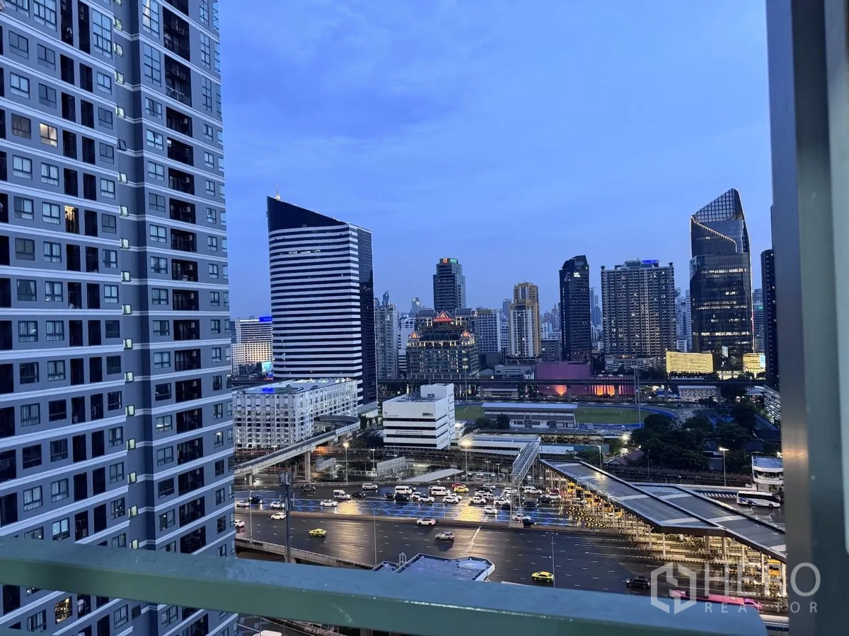 คอนโด for rent in Huai Khwang, Bangkok - วิวสกายไลน์ยามเย็นจากระเบียงชั้นสูง เห็นตึกสำนักงานและถนนคึกคัก