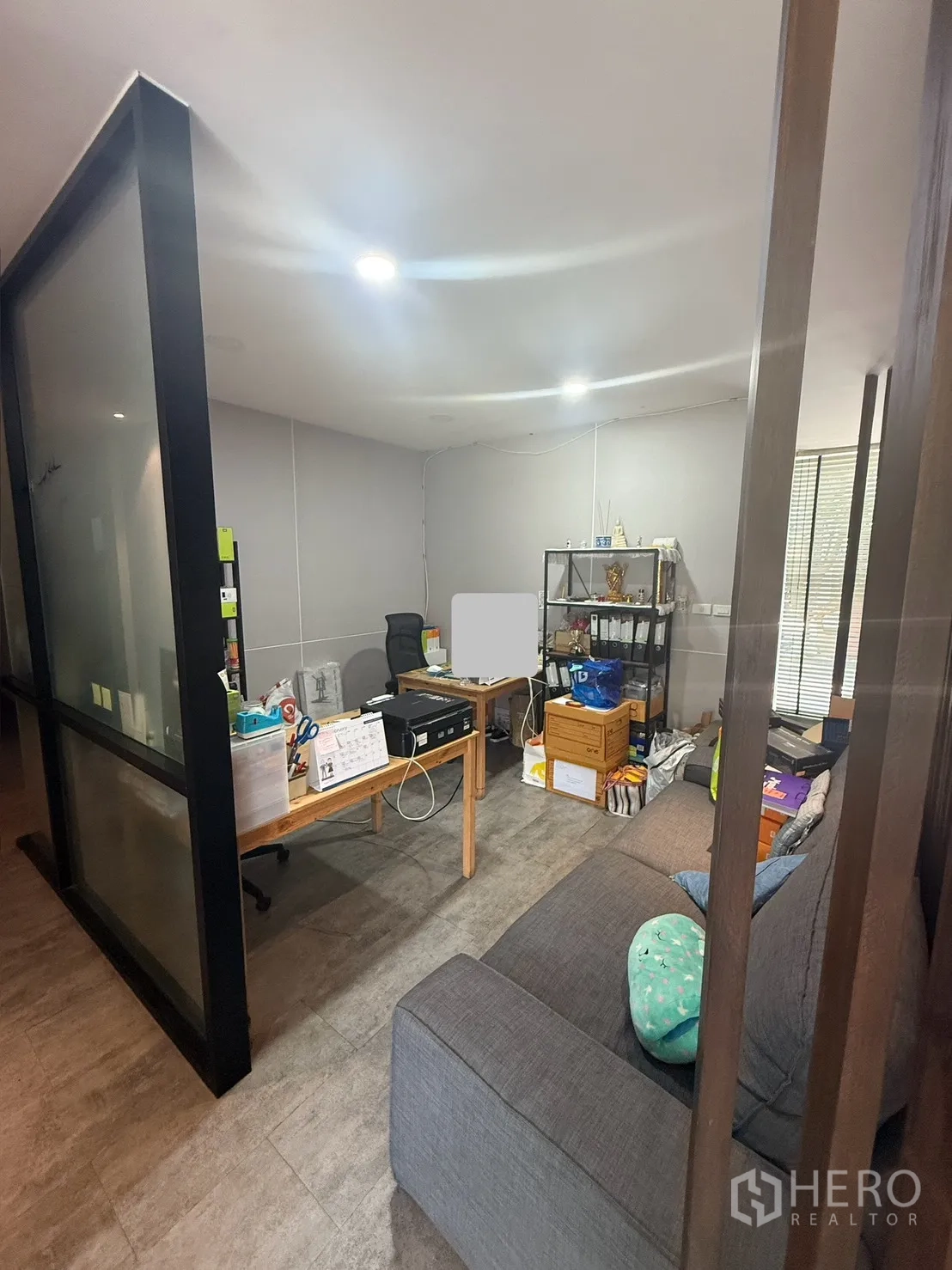 家庭办公室 for rent in Watthana, Bangkok - 玻璃隔断办公区，设书桌、置物架与灰色沙发。
