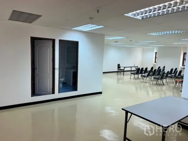 办公空间 出租在Pathum Wan, Bangkok - 宽敞开放式办公室，天花灯明亮、亮面地面、成排座椅并带独立洗手间