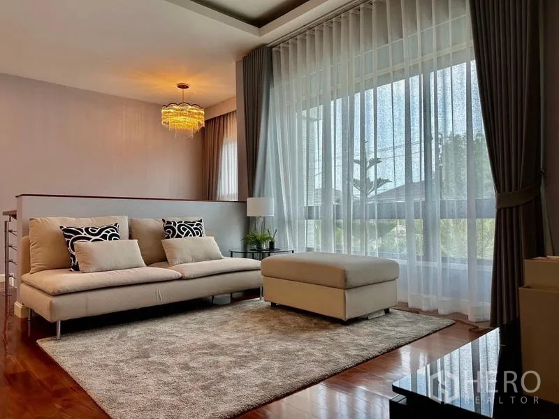 独立式住宅 出租在Lat Krabang, Bangkok - 楼上家庭区，沙发与脚凳，落地纱帘采光充足