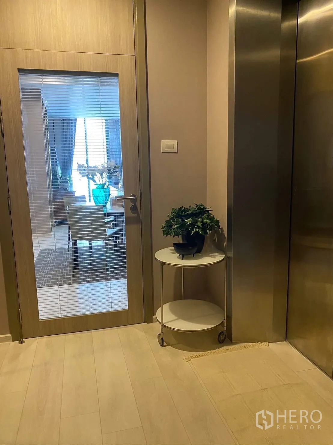 公寓 for rent in Pathum Wan, Bangkok - 私家电梯前室，玻璃门通向用餐区，旁边有放置绿植的小圆桌。