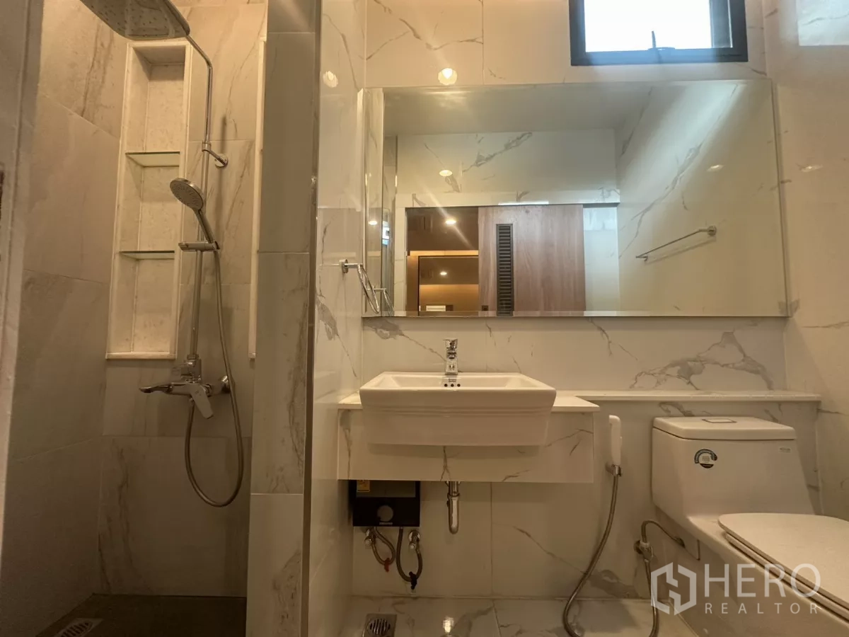 联排别墅 出租在Watthana, Bangkok - 淋浴间配雨淋花洒、玻璃隔断、台盆与坐便器。