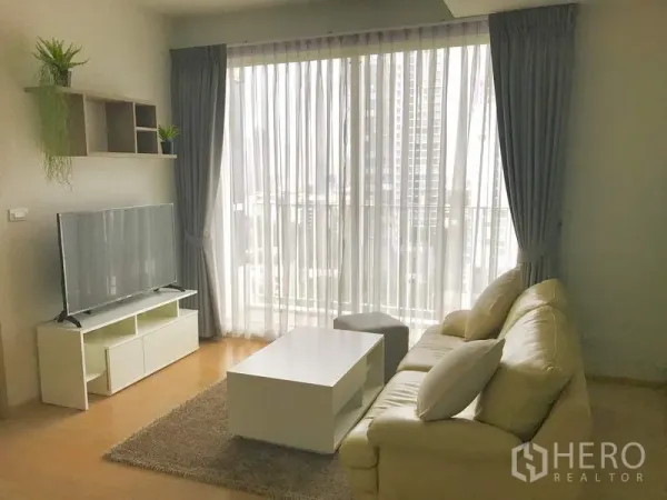 คอนโด ให้เช่าในWatthana, Bangkok - ห้องนั่งเล่นอบอุ่น โซฟา โต๊ะกลาง และหน้าต่างเต็มบานพร้อมผ้าม่านโปร่ง