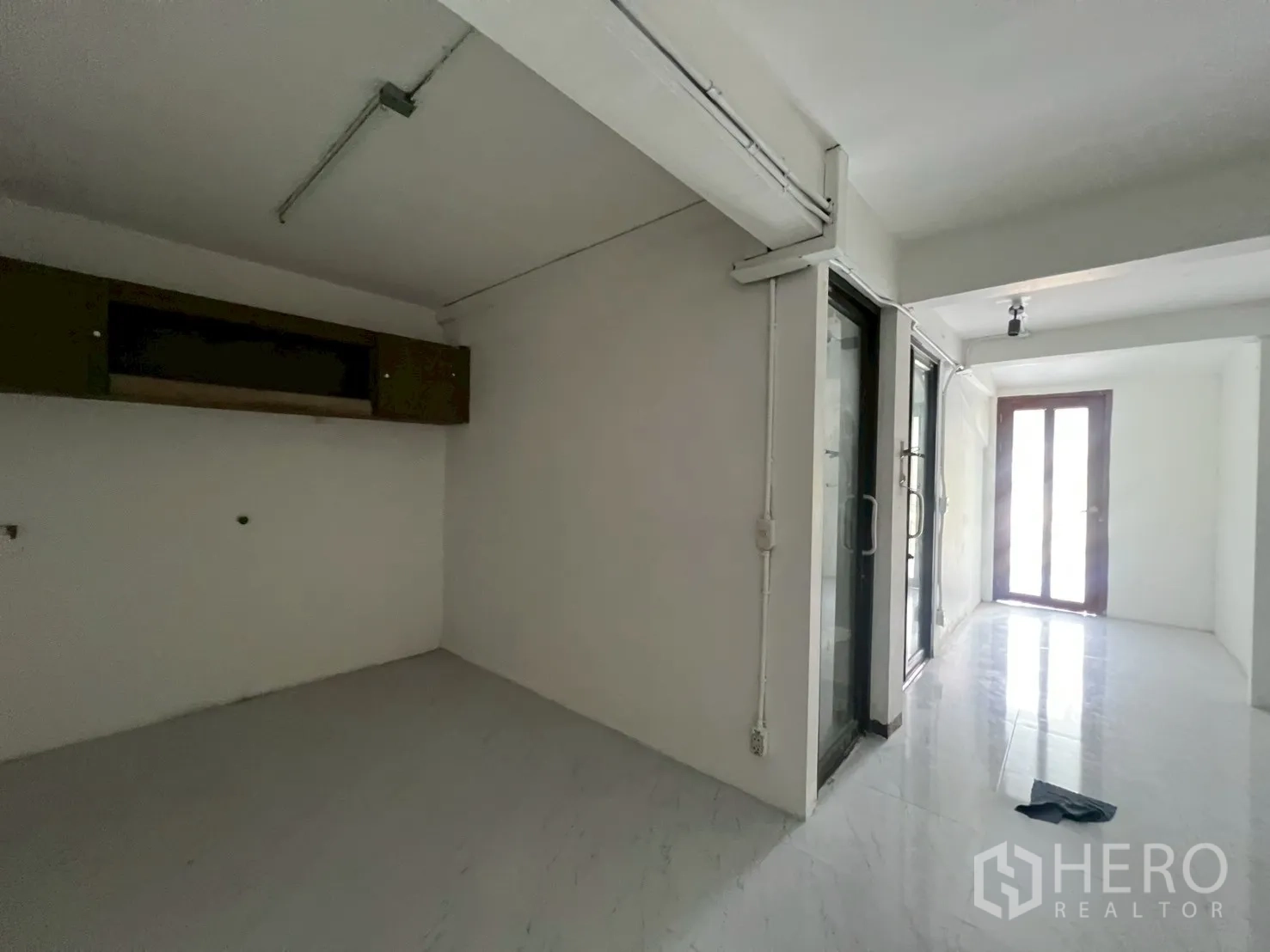 Home Office for rent in Watthana, Bangkok - Compact room with sliding glass doors and a doorway to a small terrace.