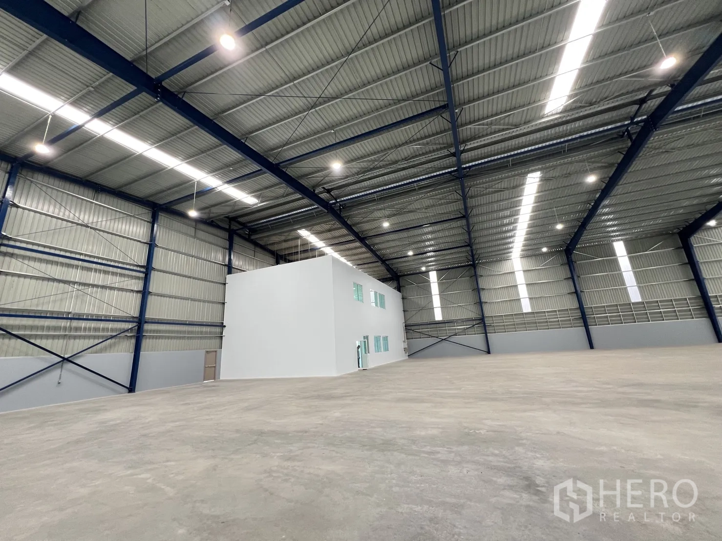 Warehouse for rent in Mueang Samut Prakan, Samut Prakan - Interior view showing a freestanding white office core inside the warehouse hall.