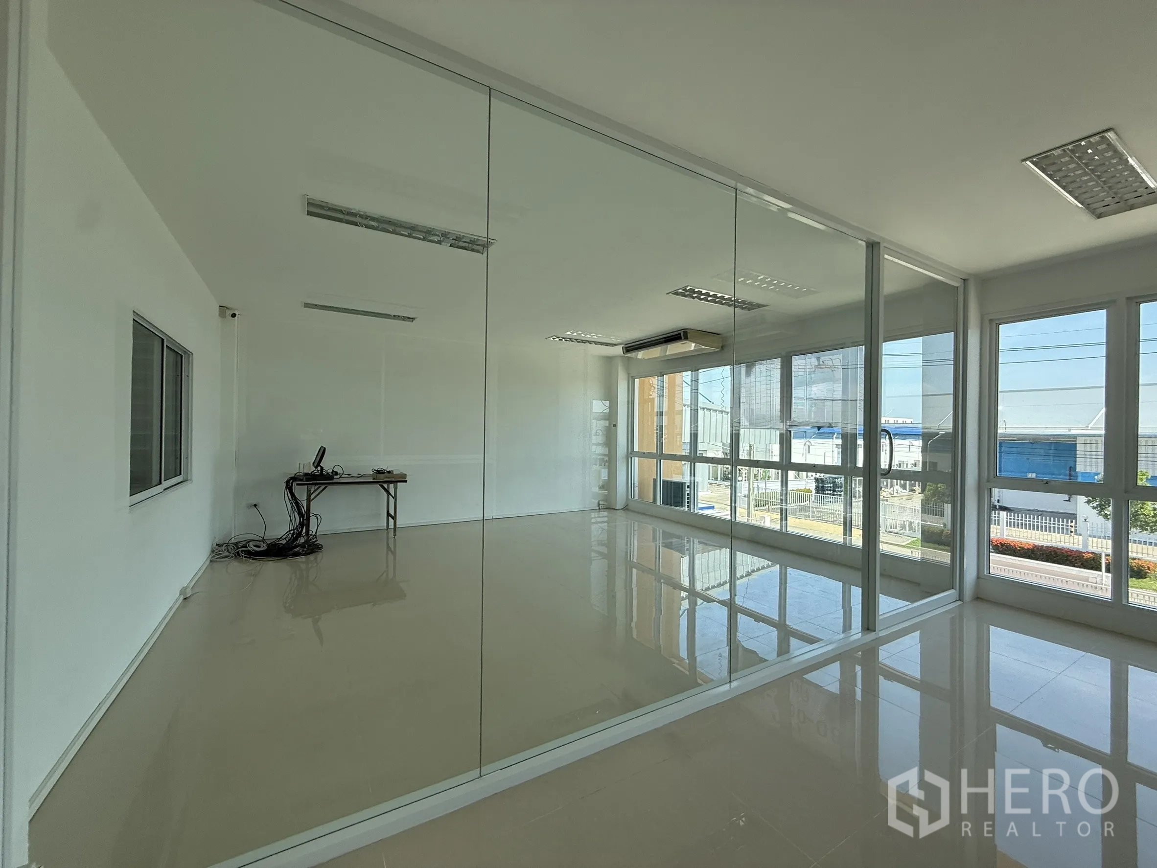 Warehouse for rent or sale in Bang Bo, Samut Prakan - Glass‑walled office on the upper level with street and estate views.