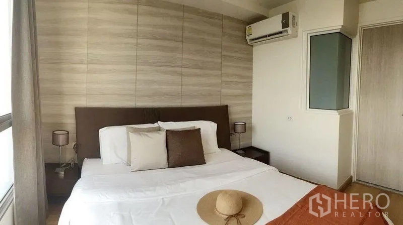 คอนโด ให้เช่าในWatthana, Bangkok - ห้องนอนอบอุ่น เตียงคู่ ผนังลายไม้ และเครื่องปรับอากาศติดผนัง