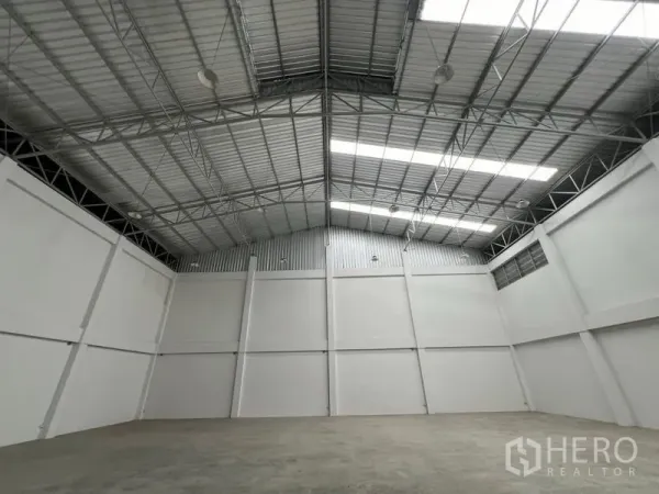 Factory for rent in Phra Samut Chedi, Samut Prakan - Clear-span manufacturing hall with insulated roof panels, skylight strips and smooth concrete slab.