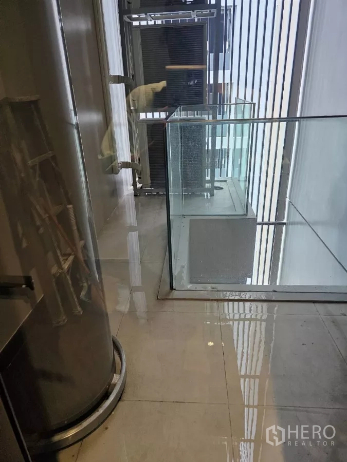 公寓 出租在Watthana, Bangkok - 生活阳台，瓷砖地面、玻璃栏杆与室外空调机组。