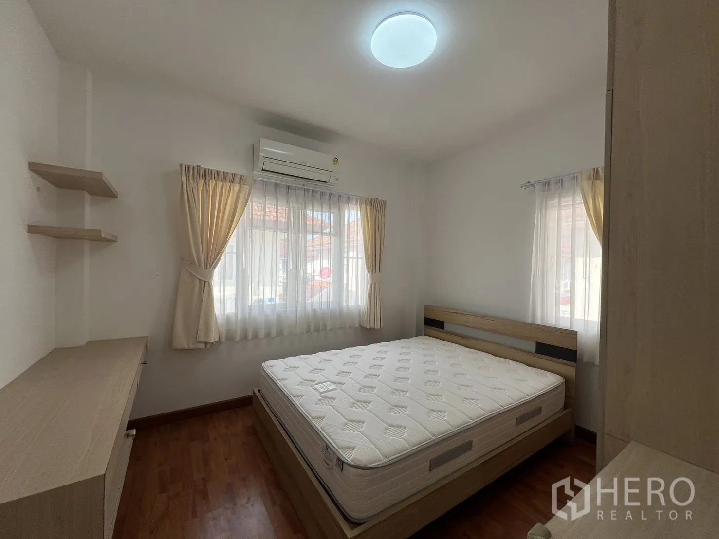 独立式住宅 出租在Bang Kapi, Bangkok - 卧室单人床、低柜与通往走廊的房门。