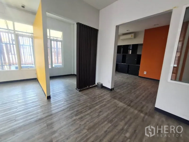 Retail Space for rent in Watthana, Bangkok - Flexible retail zones with a black slatted divider and an orange accent wall.