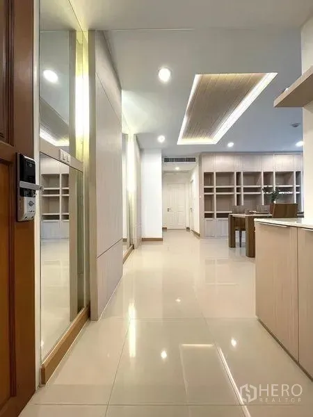 Condominium for rent - Entrance hallway of a 2-bedroom condo with glossy floors, built-in cabinetry and cove lighting in Watthana near BTS Phrom Phong.