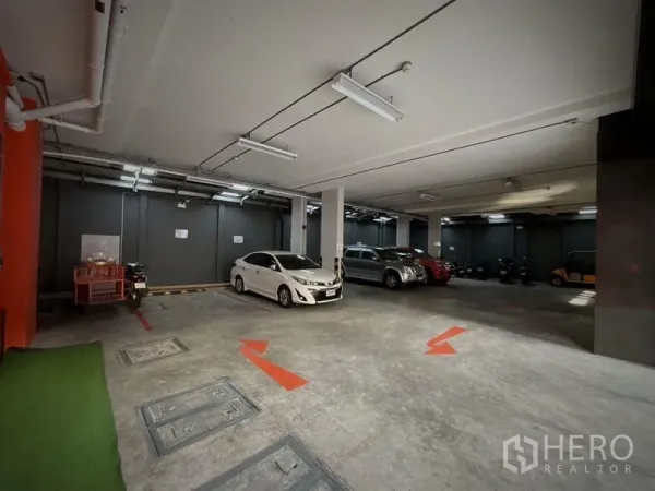 店屋 出租或出售在Khlong Toei, Bangkok - 室内有顶停车场，划线车位与指示箭头。