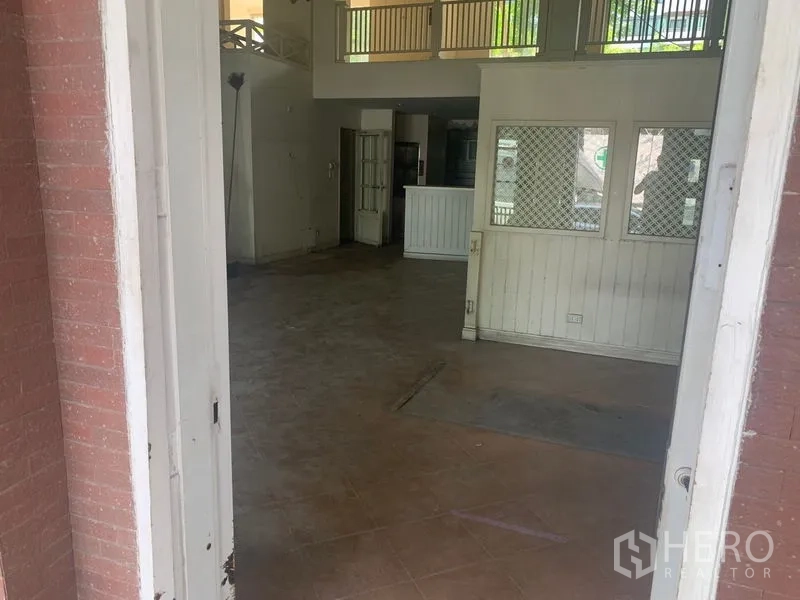 Shophouse for rent in Watthana, Bangkok - Entry view into open-plan shop area with lattice windows and double doors.