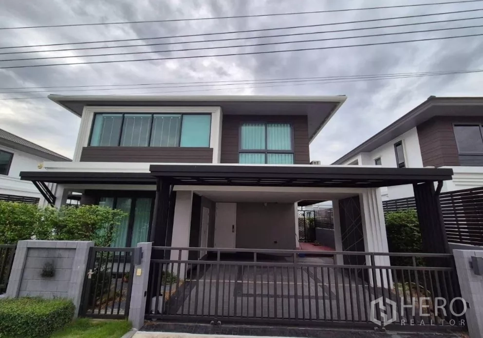 Detached House for sale in Bang Kruai, Nonthaburi - Modern two‑storey detached house facade with gated carport and hedges in Bang Kruai, Nonthaburi.