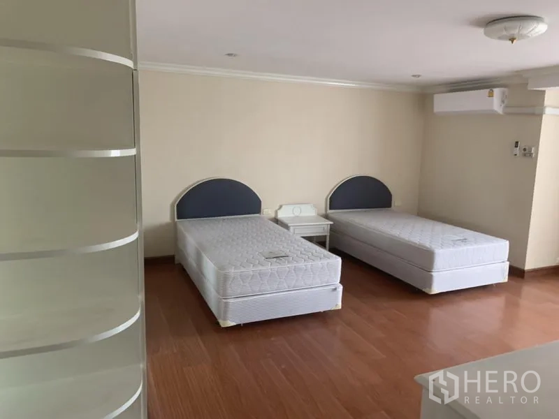 公寓 出租在Watthana, Bangkok - 次卧放置两张单人床，木地板与壁挂式空调。
