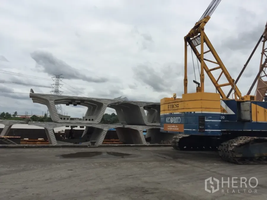 货栈 出租在Pathum Thani - 露天工业场地，履带式起重机与堆放的预制混凝土构件，位于木昂巴吞他尼的仓库。
