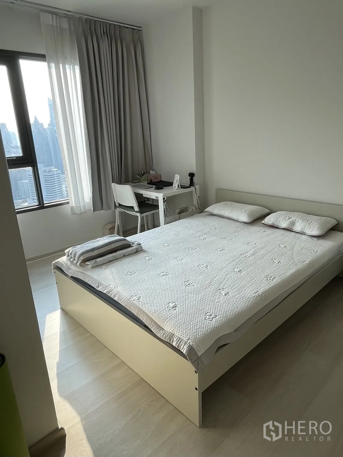 公寓 for rent in Pathum Wan, Bangkok - 明亮卧室，双人床、城市景观窗、书桌与全高窗帘。