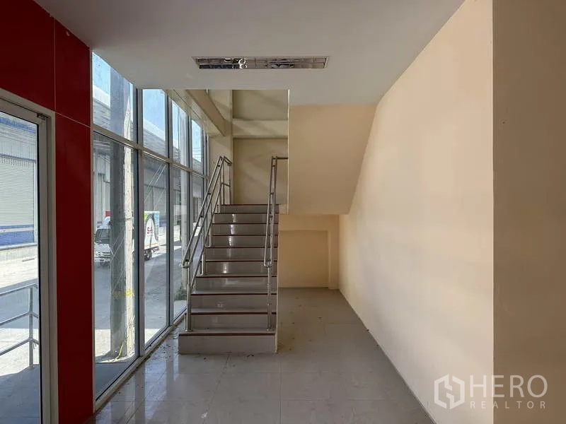 工厂 出租在Bang Phli, Samut Prakan - 大面积落地玻璃门厅，楼梯通往夹层办公室。