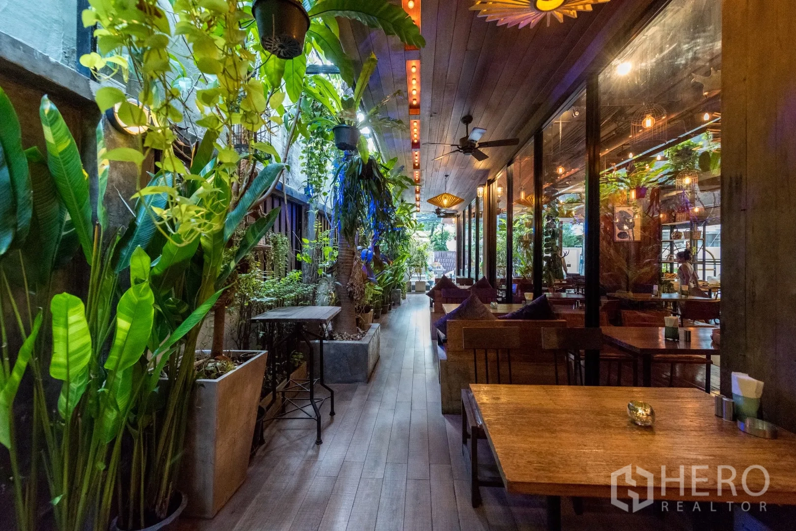 Retail Space for rent in Watthana, Bangkok - Outdoor corridor with garden plants, glass wall to dining room, and warm pendant lighting.