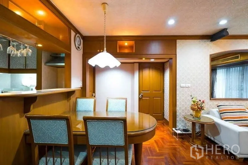 公寓 出租或出售在Bang Phlat, Bangkok - 餐区设椭圆餐桌与吊灯，吧台与厨房相连。